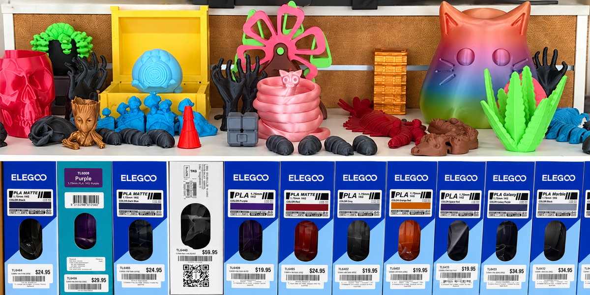Colourful 3D printed examples above boxed filament at Delacey’s in Bowen