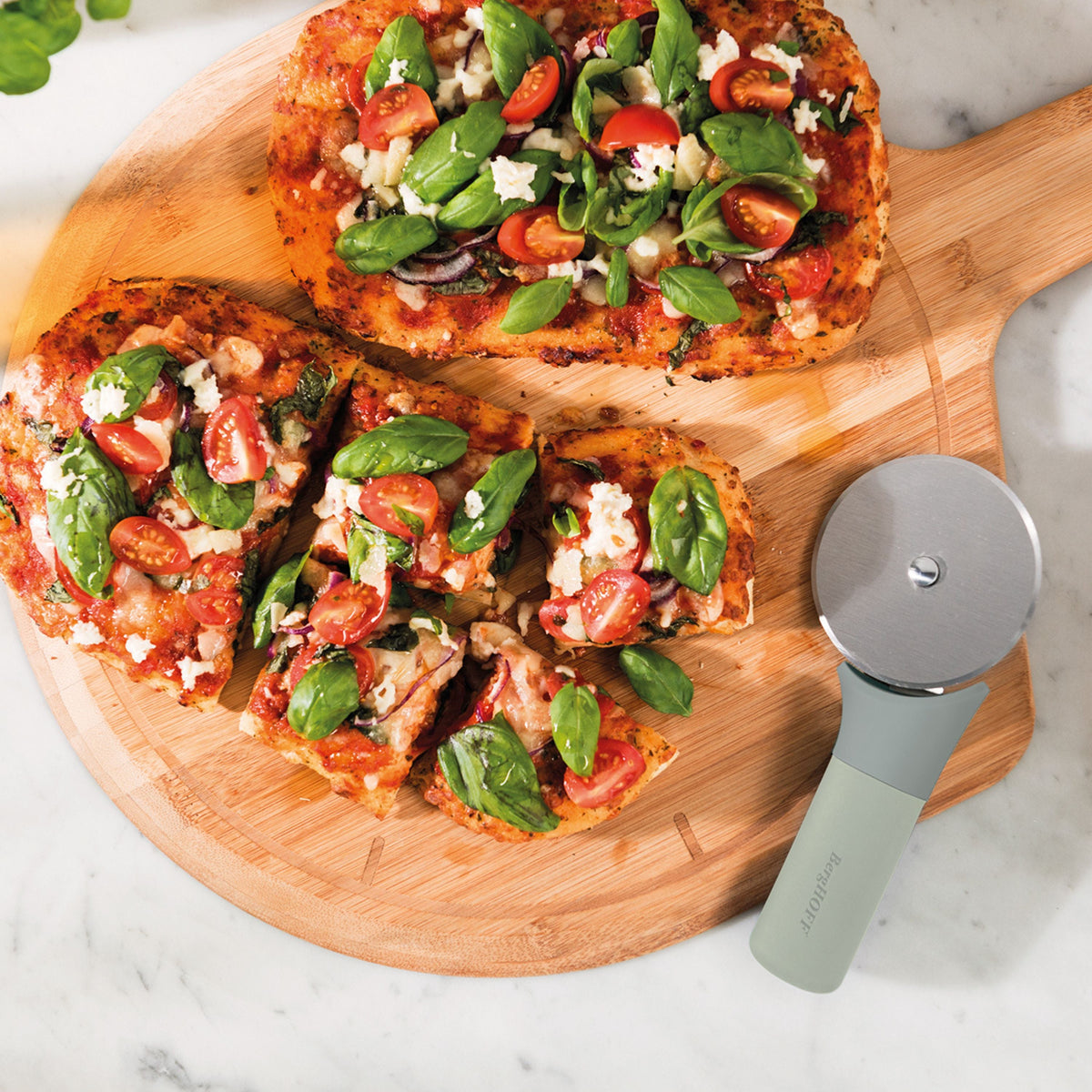 BergHOFF Balance pizza cutter beside sliced pizza