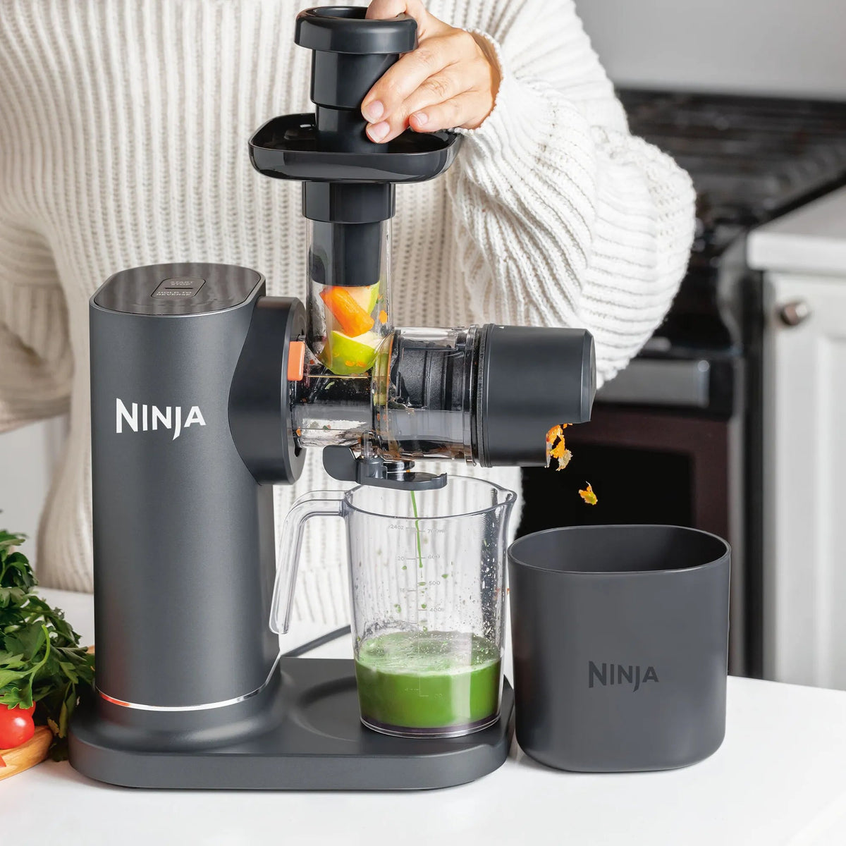 Ninja NeverClog JC151 juicer with fruit loaded through feed chute