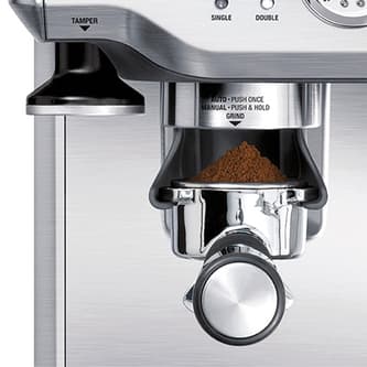 Breville BES870BSS Barista Express grinding coffee into the portafilter