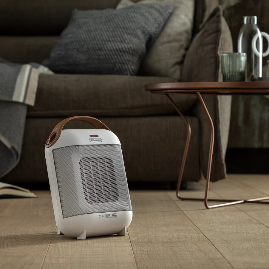 DeLonghi HFX30C18IW ivory white Capsule heater beside a sofa